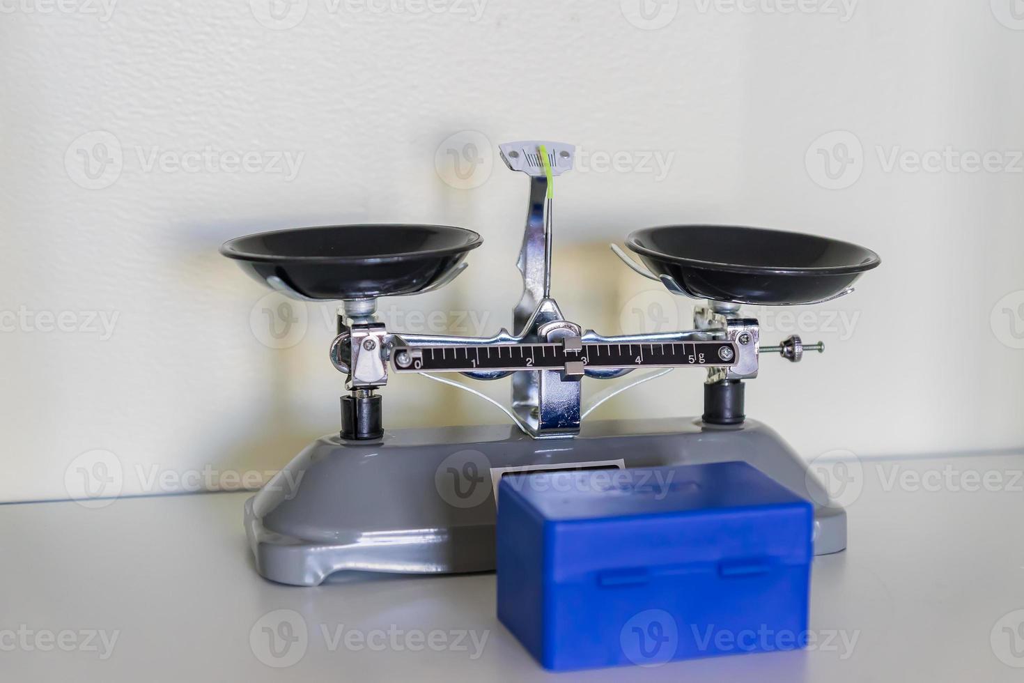 gray laboratory scales on shelf, blue plasic box with weights photo