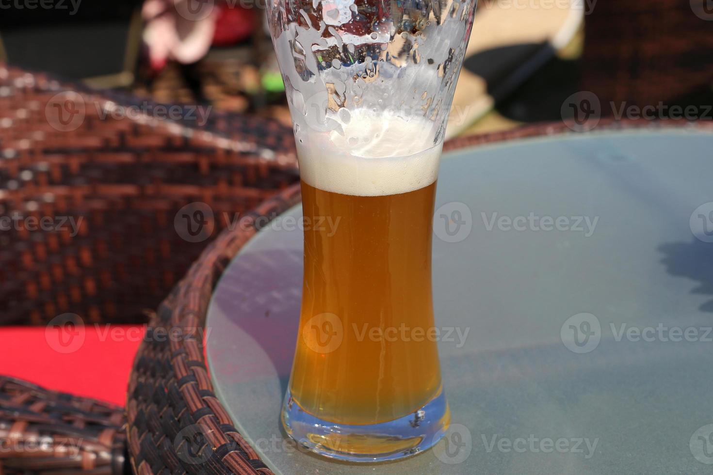 On the table in a glass of fresh and cold beer. photo