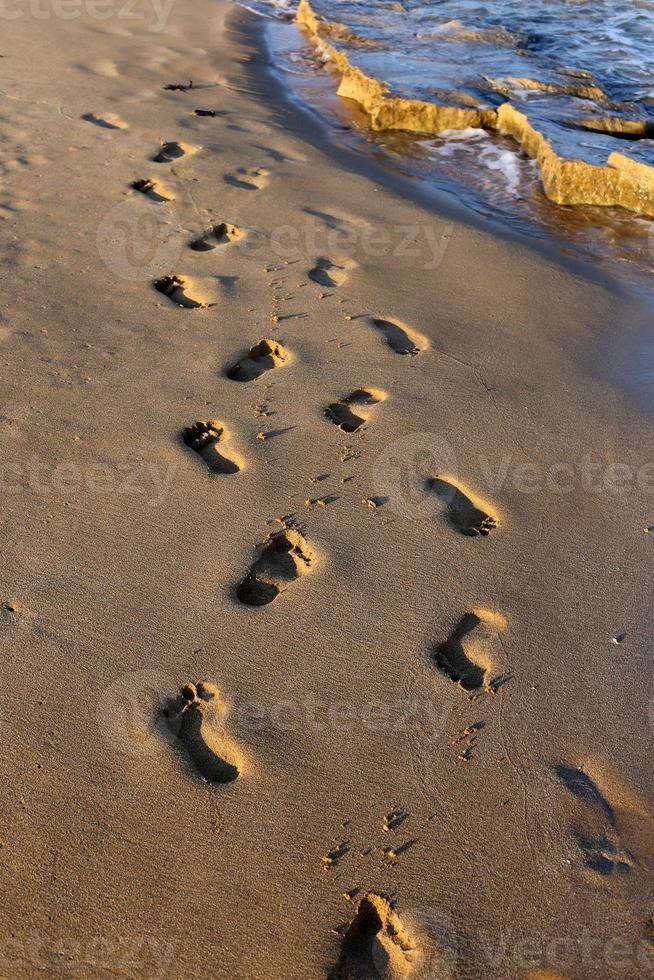 Footprints in the sand on the city beach. photo