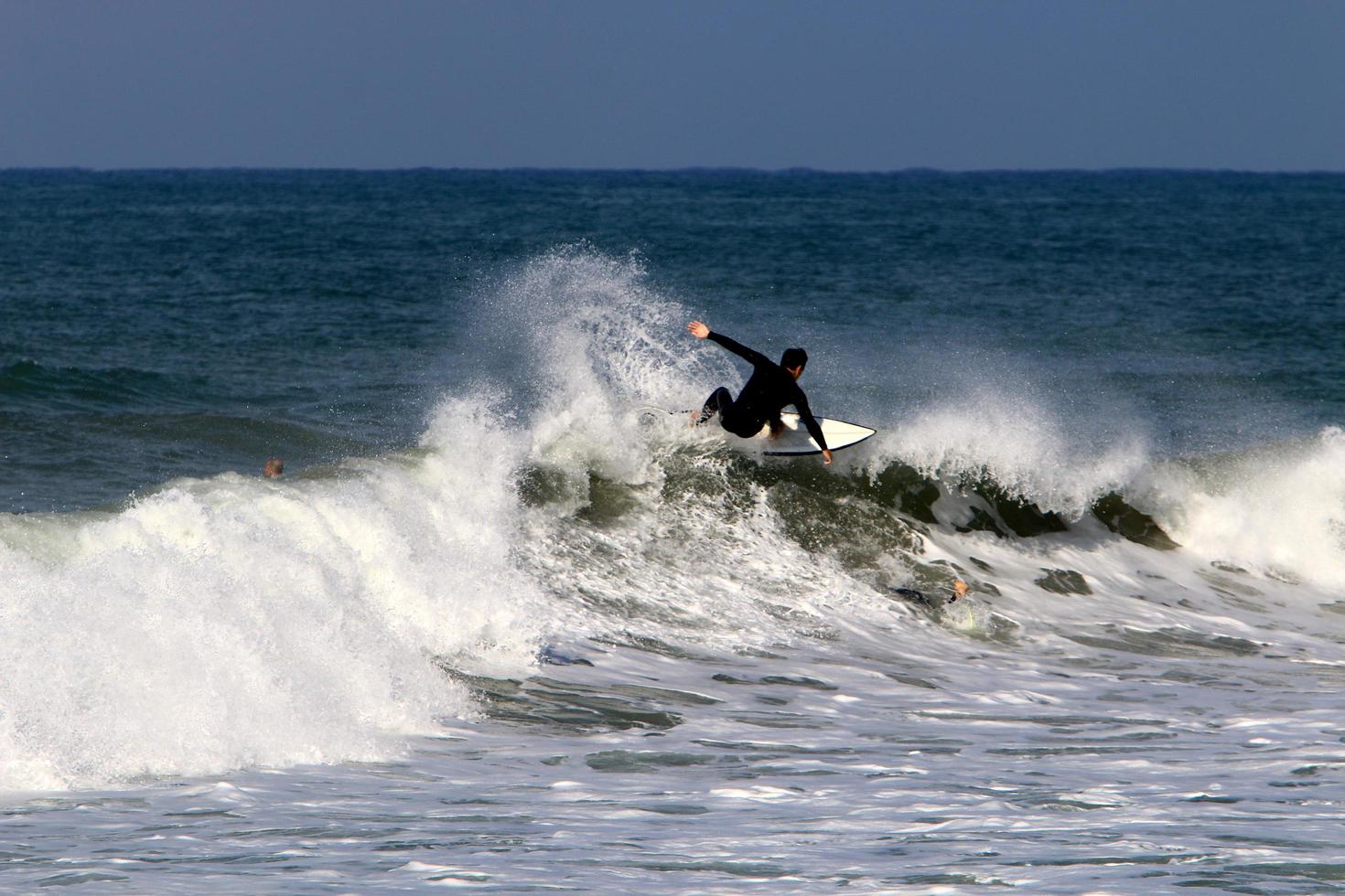 December 21, 2018 Israel. Surfing on high waves in the Mediterranean. photo