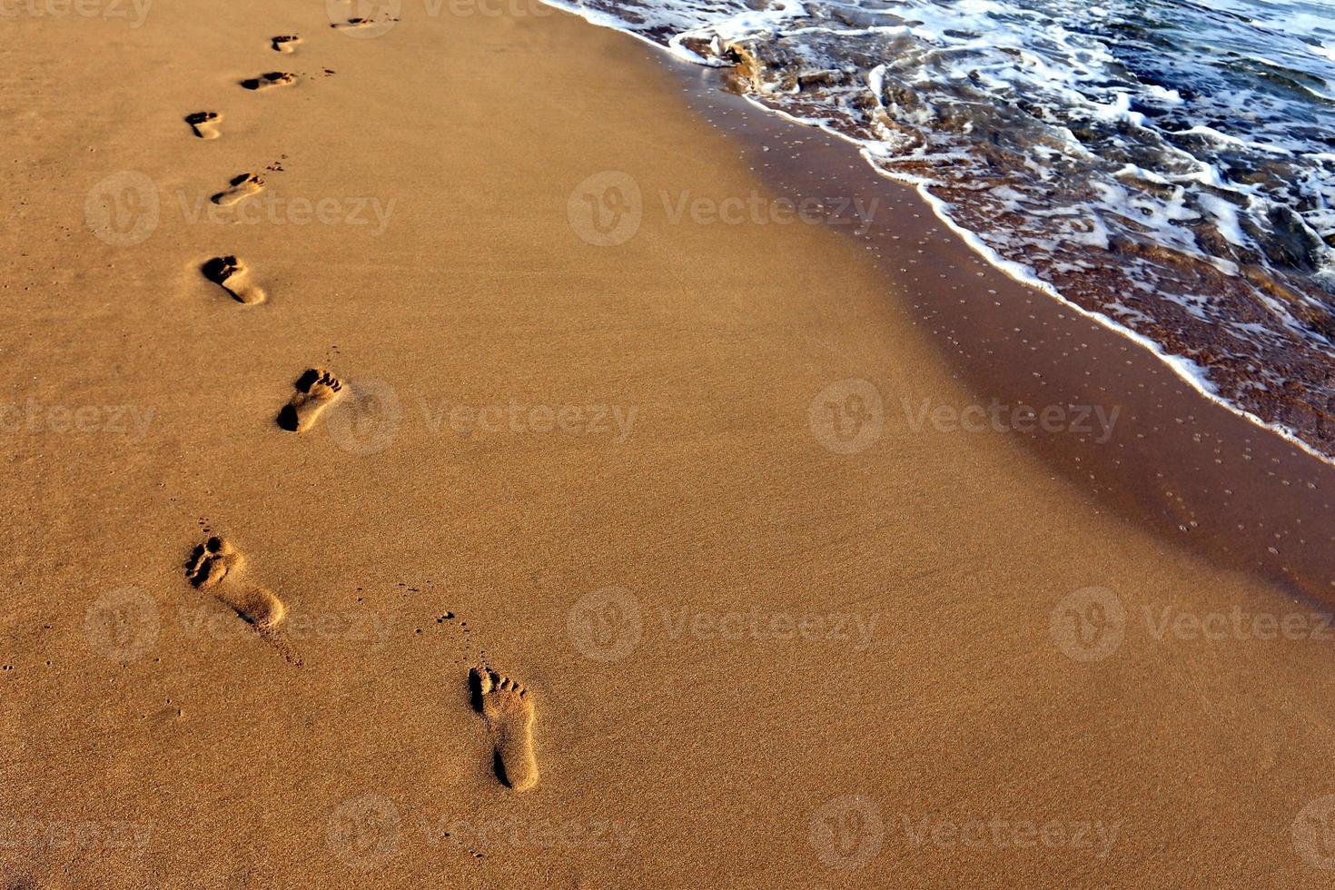 Footprints in the sand on the city beach. photo