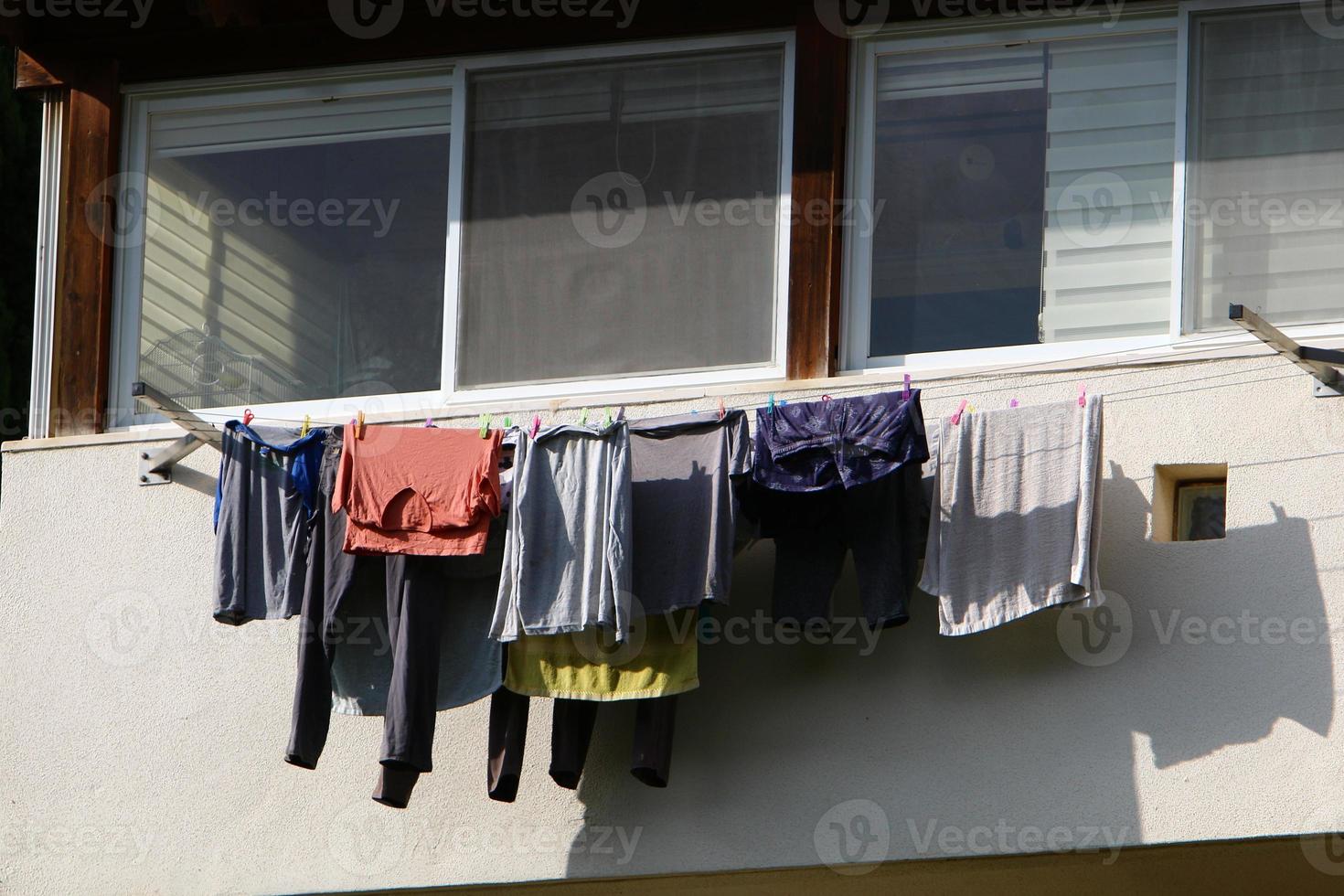 Washed linen dries on the street outside the window of the house. photo
