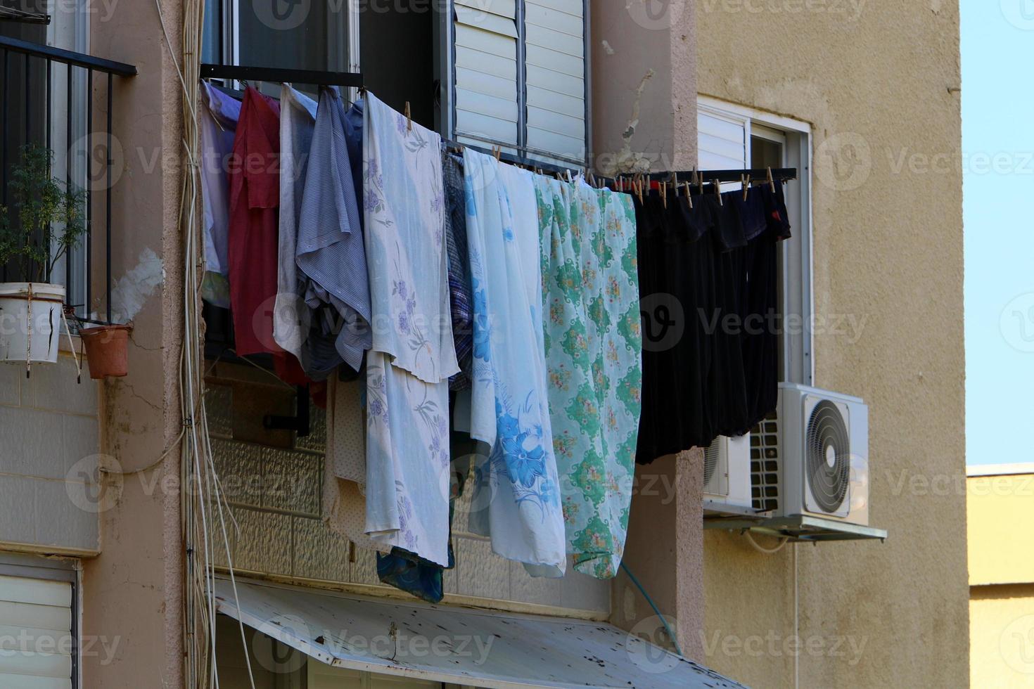 Washed linen dries on the street outside the window of the house. photo