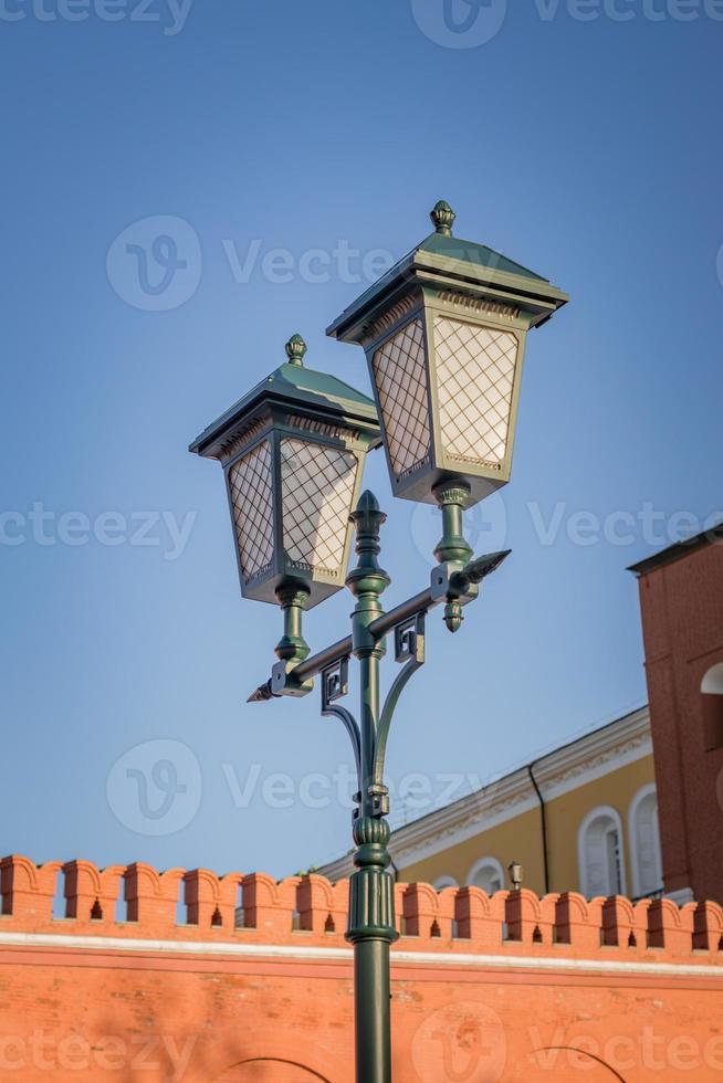 antique lamp post on kremlin wall and blue sky background photo