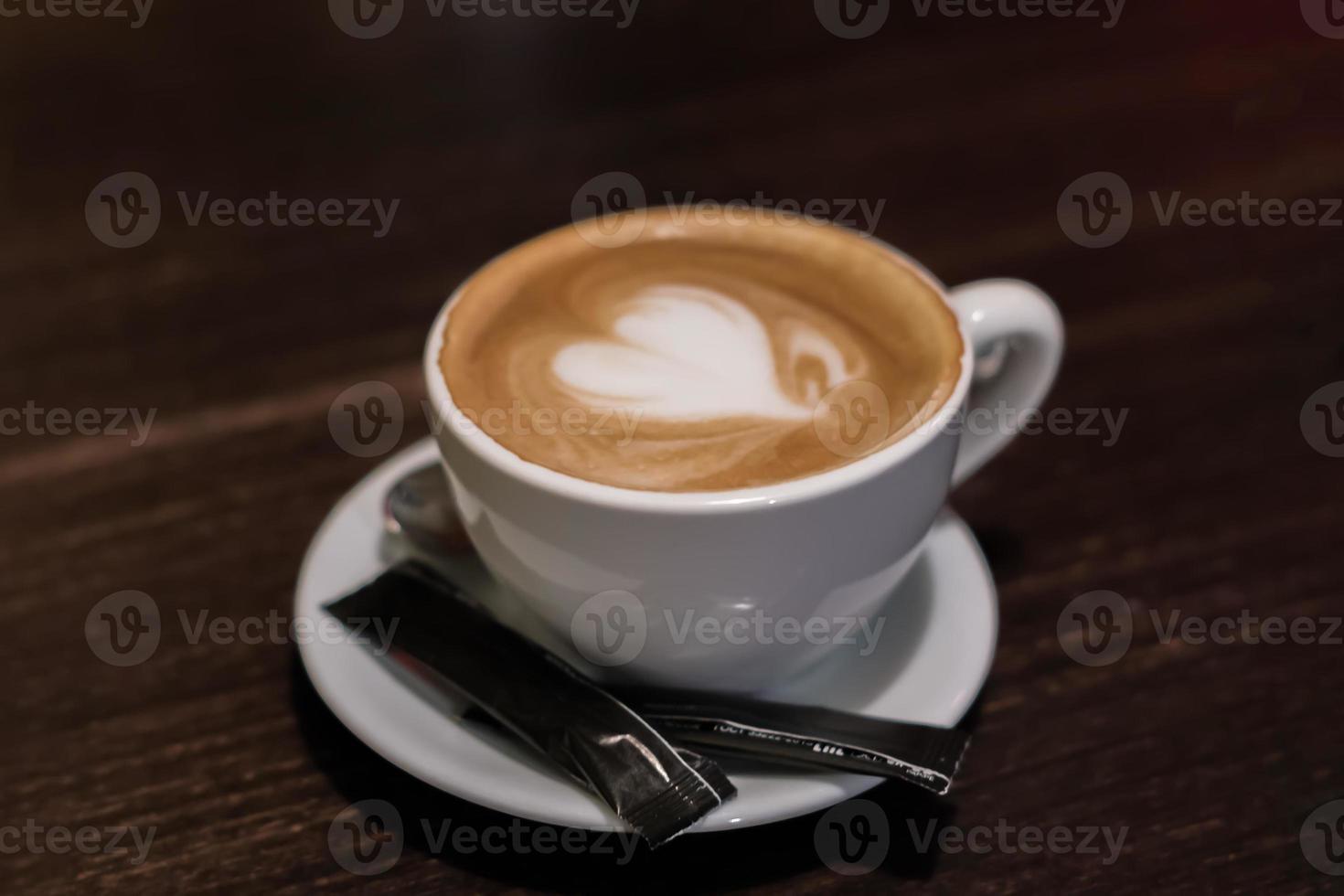 cup of cappuccino with heart on wooden table closeup photo