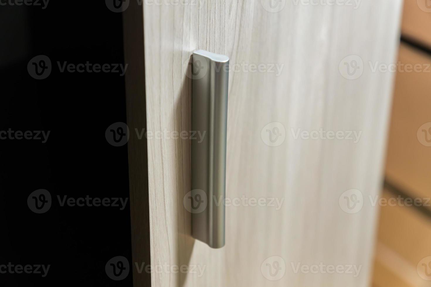 wardrobe open door. Closeup of wooden door with metal handle photo