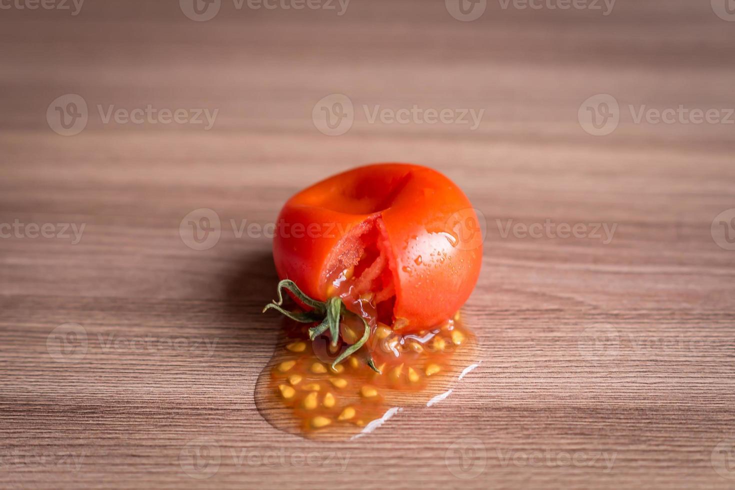 smashed tomato on wooden table photo