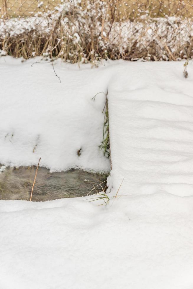 snowy bridge over a stream covered with ice photo