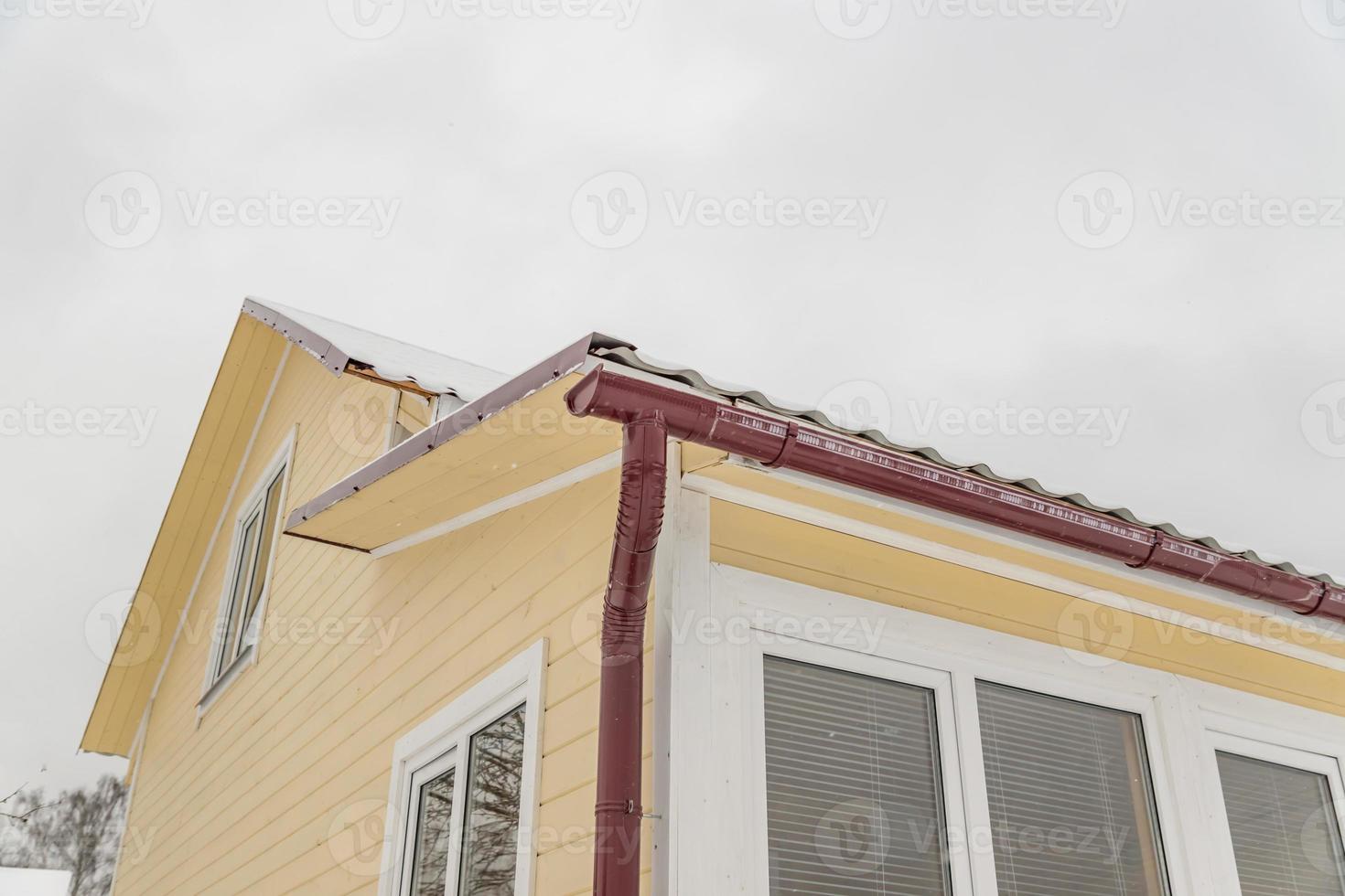 Corner of the house with gutter in winter photo