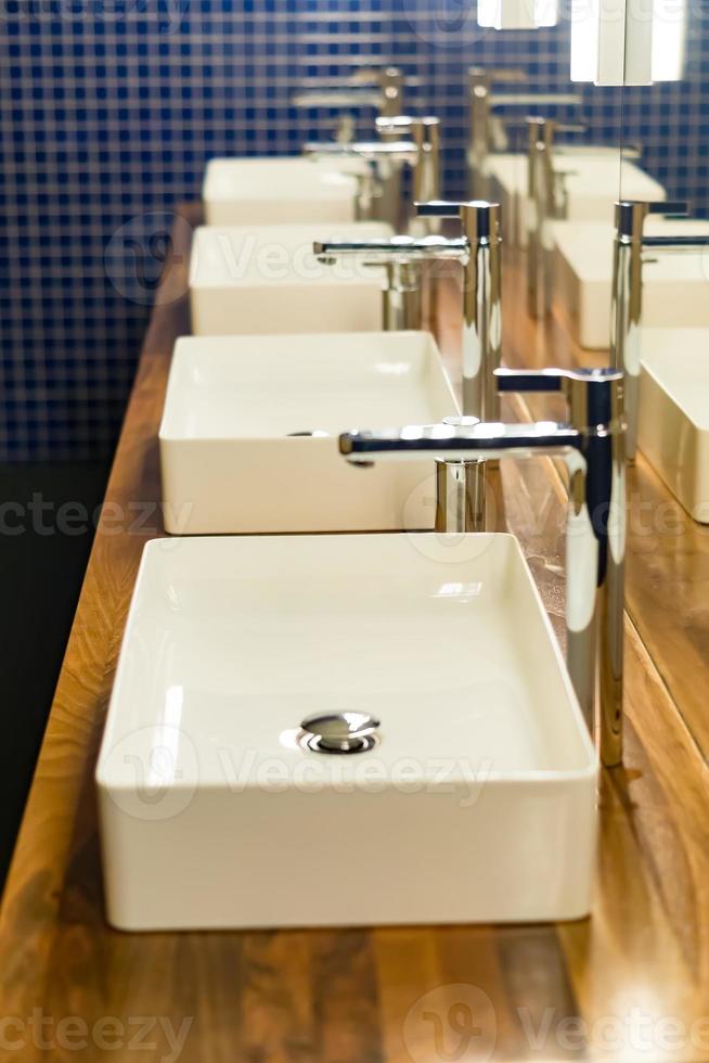 Row of wash sinks in public bathroom, closeup photo