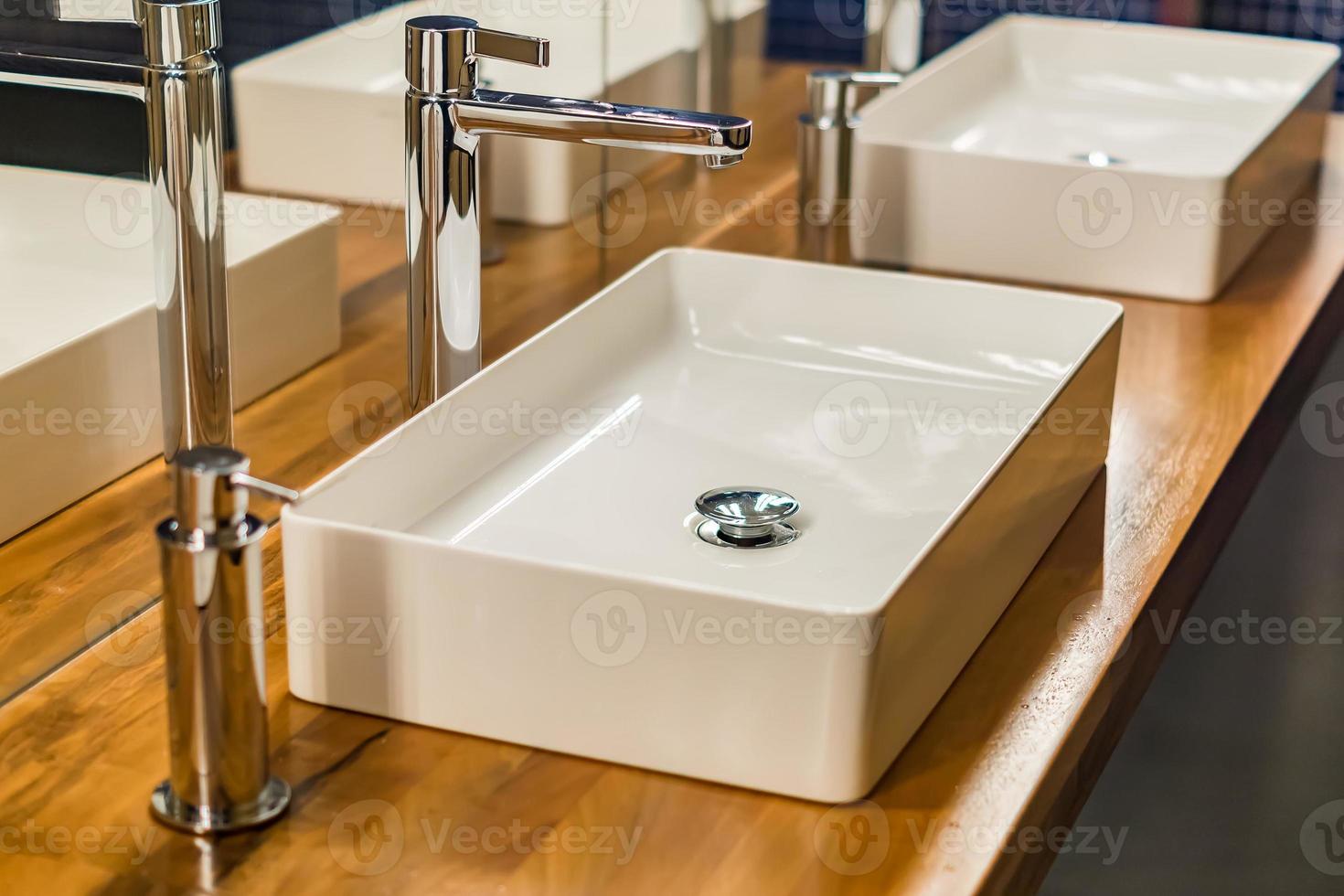 Row of wash sinks in public bathroom, closeup photo