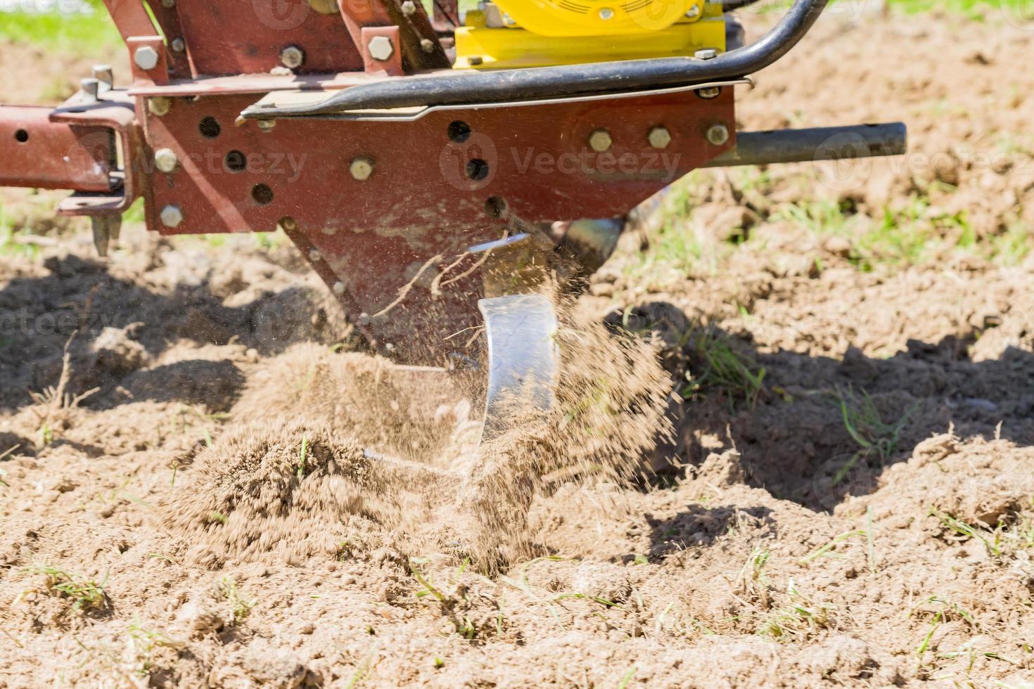 close up of a tractor motoblock plowing the field photo