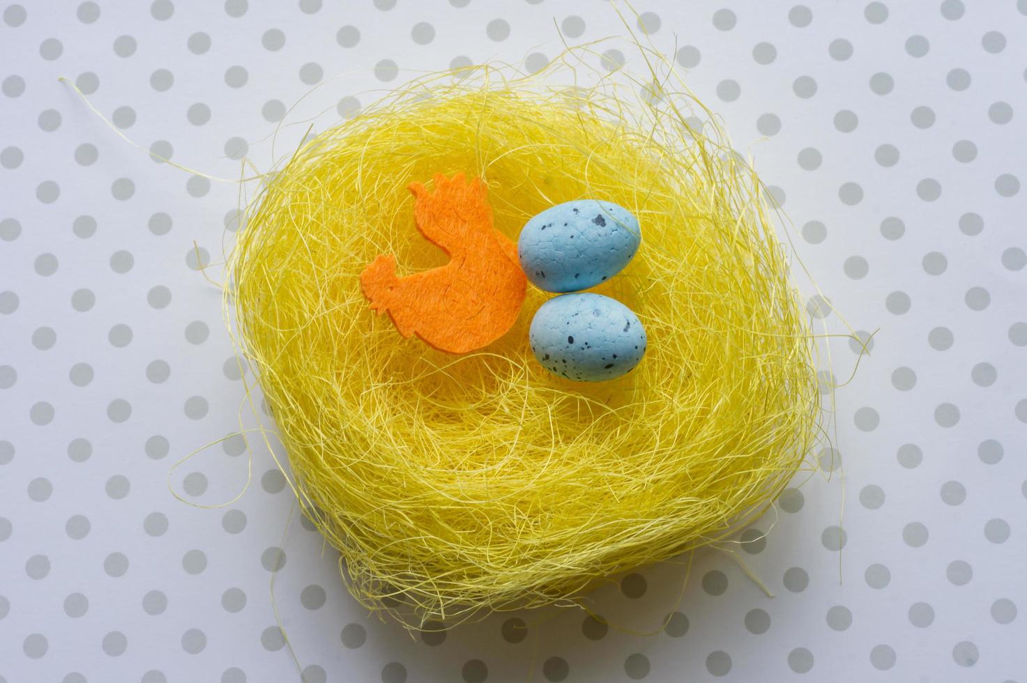 Artificial easter nest with two eggs and cock photo