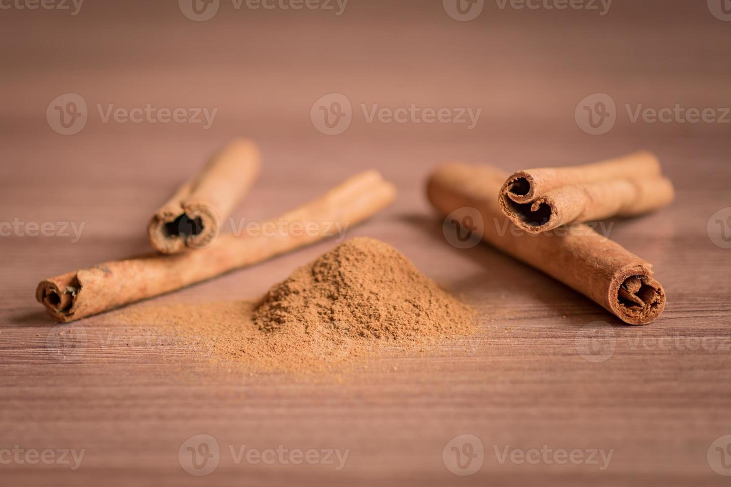 cinnamon sticks and powder on wooden table. photo