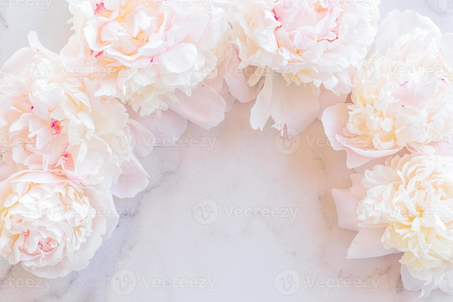 Template for a romantic greeting card with creamy peonies on a white marble background. Blossoming flowers on a white background. pink peonies on a white marble table, flat lay. photo