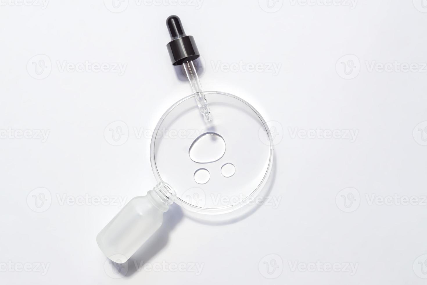 Cosmetic pipette serum on a petri dish on white background. Cosmetology and pharmaceuticals concept. Acid peeling, face oil, collagen photo