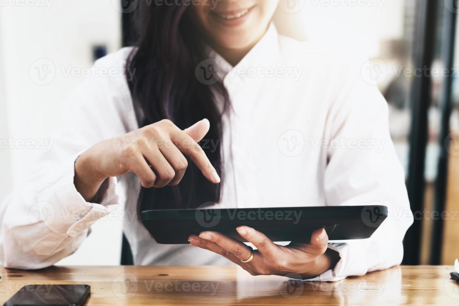 Woman using ipad for working in office room. photo