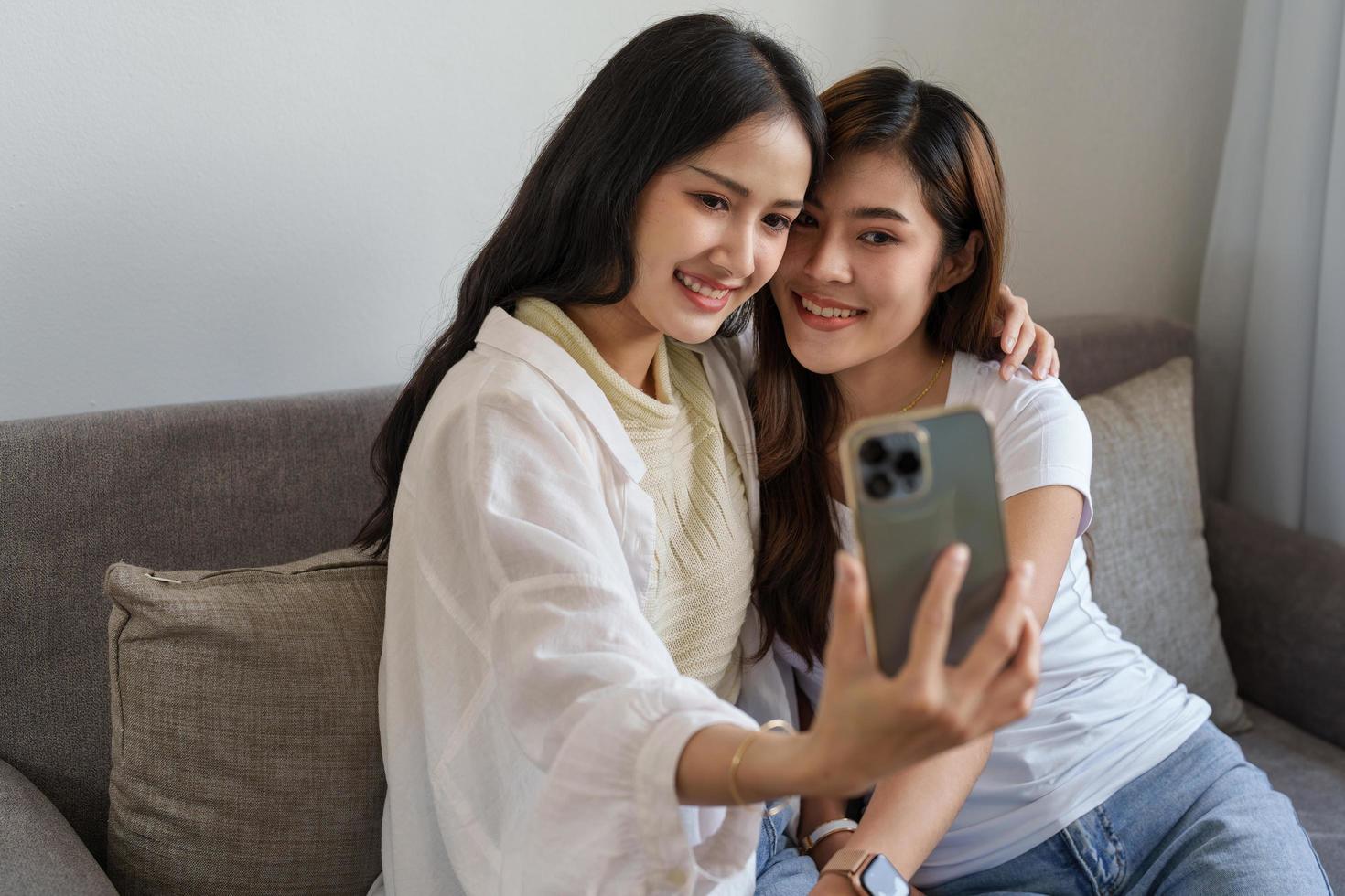 lgbtq, lgbt concept, homosexuality, portrait of two asian women enjoying together and showing love for each other while using smartphone mobile to take selfies photo