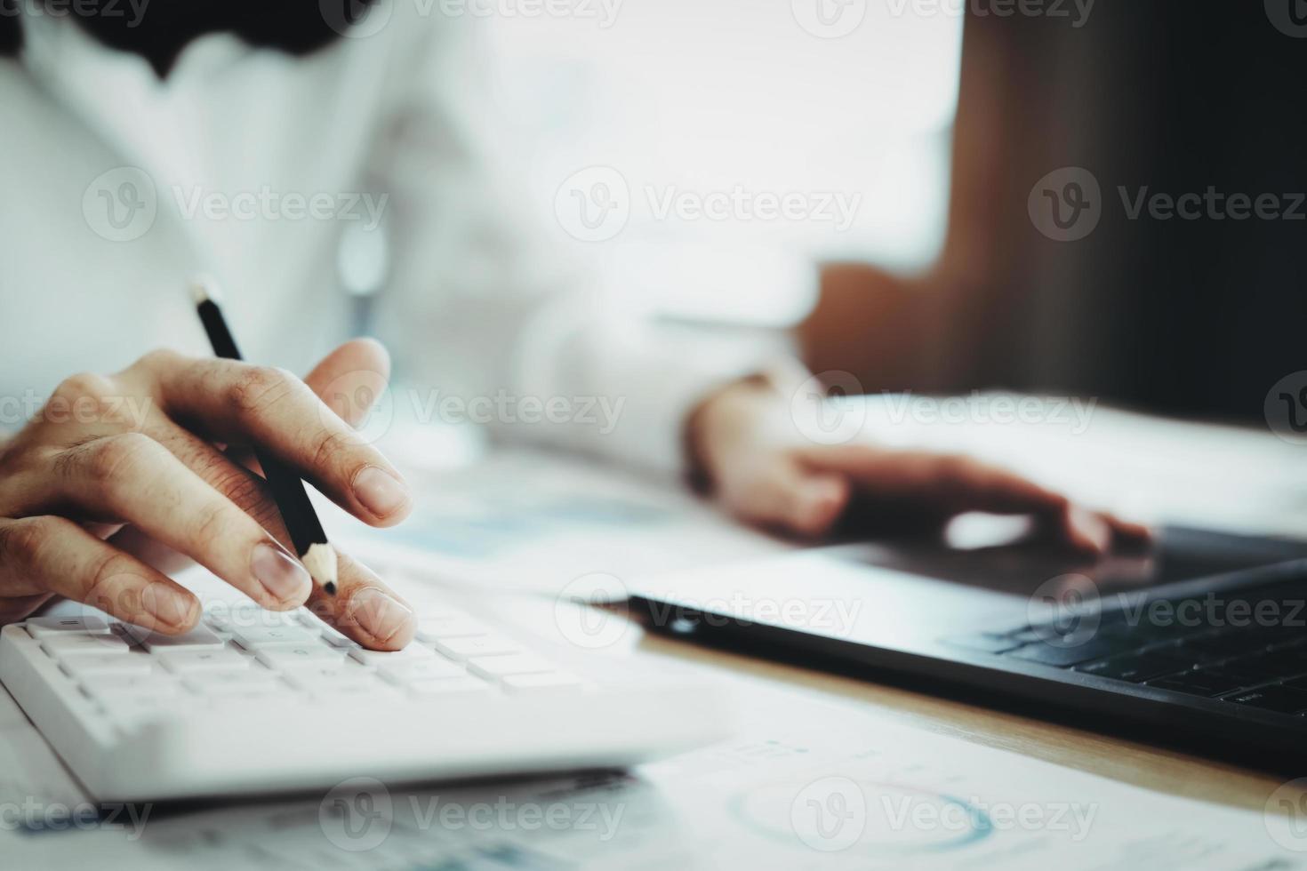 Business woman using calculator to review balance sheet annual  using  document and laptop computer to calculating budget. audit and Check integrity before investment concept. photo