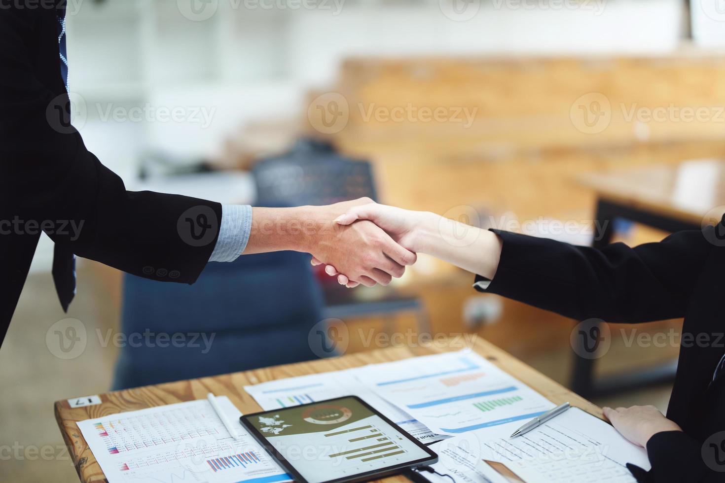 Asian entrepreneurs handshakes to congratulate the agreement between the two companies to enhance investment and financial strength. deal concept photo