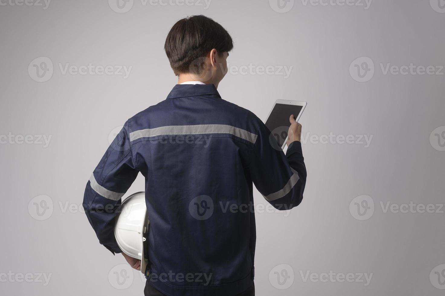 Portrait of male engineer wearing a protective helmet over white background studio. photo