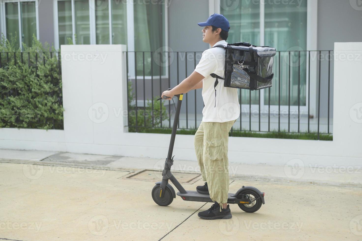 repartidor sonriente con mochila térmica montando en un scooter eléctrico,  entrega concepto en línea 10001917 Foto de stock en Vecteezy