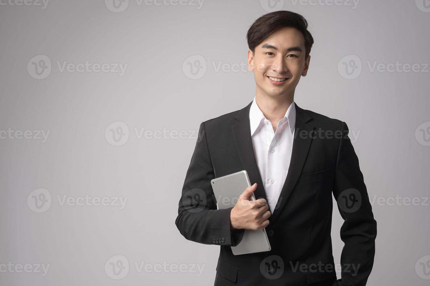 joven empresario vistiendo traje sobre estudio de fondo blanco foto