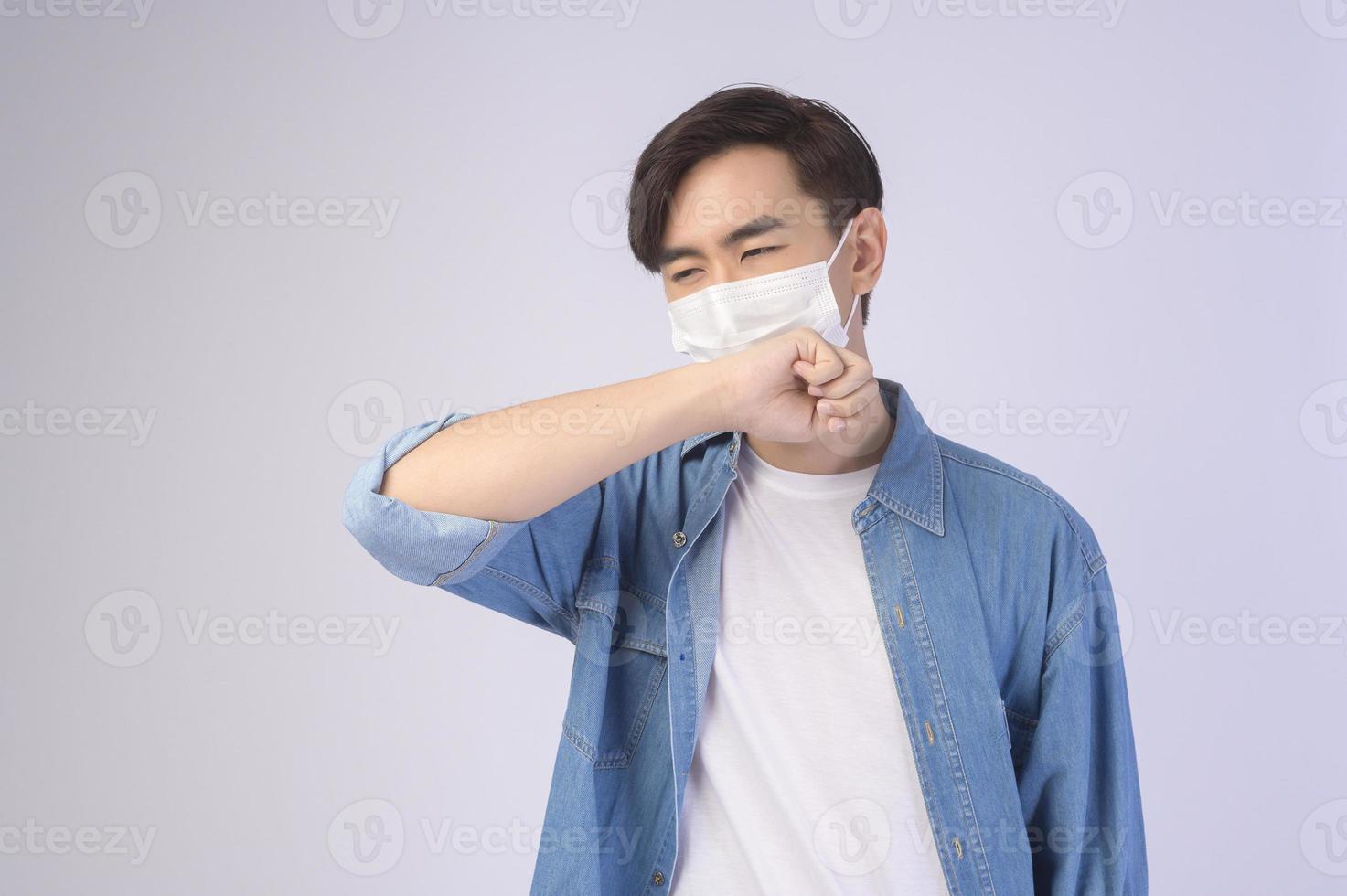 Young asian man wearing protective mask over white background studio, safety travel , new normal , social distancing , covid19 and pandemic concept. photo