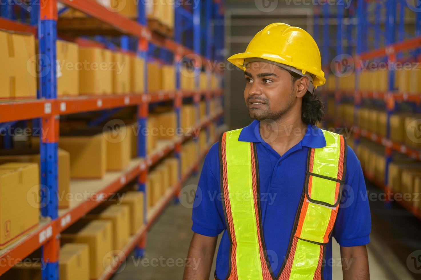 Portrait of young mixed race male worker wearing helmet in modern warehouse storage of retail shop photo