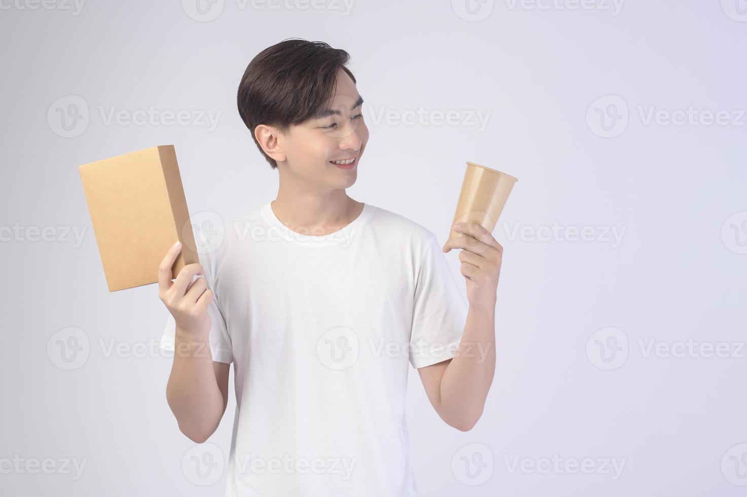 Young asian man holding paper cup and paper box over white background, Save earth concept photo