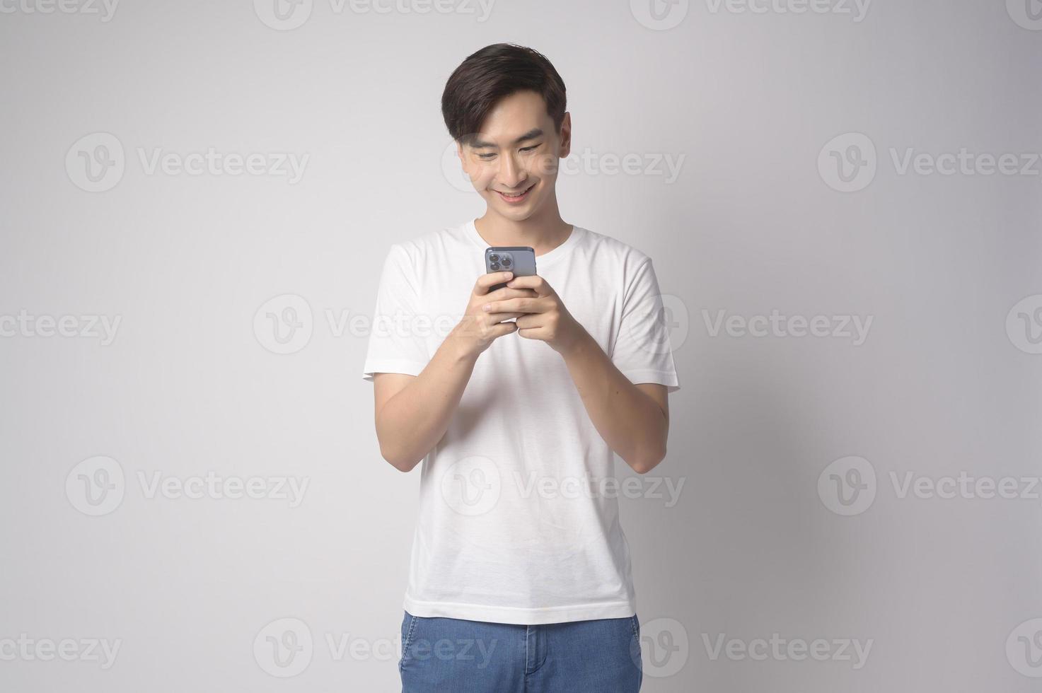 Young asian man using smartphone over white background, technology concept. photo