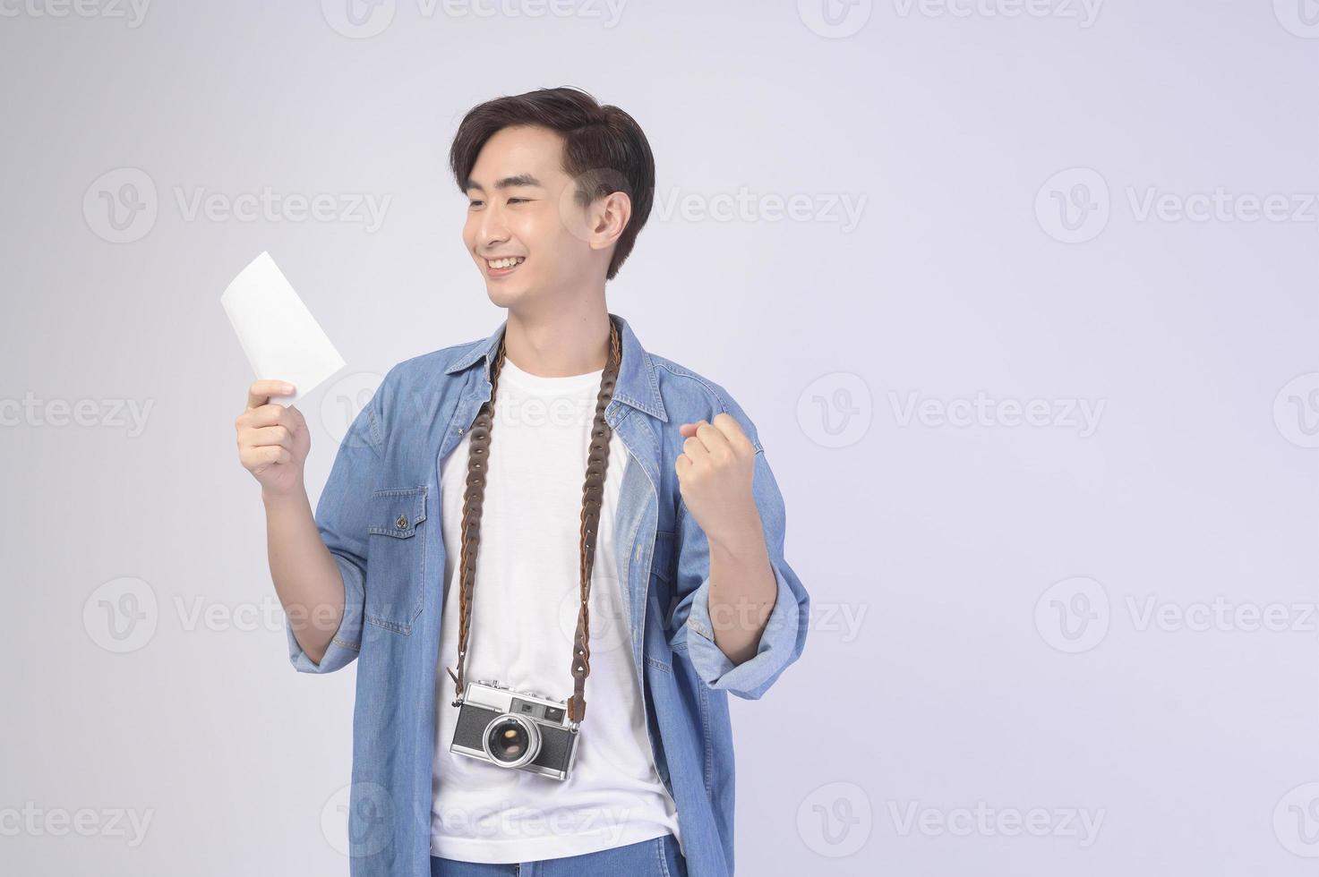 Young happy asian tourist man over white background studio, travel and holidays concept. photo