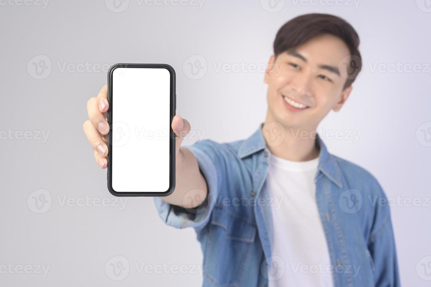 Young asian man using smartphone over white background, technology concept. photo