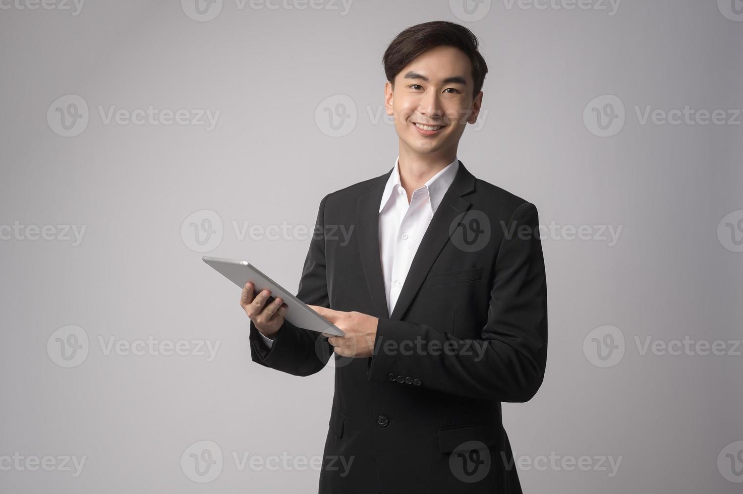 joven empresario vistiendo traje sobre estudio de fondo blanco foto