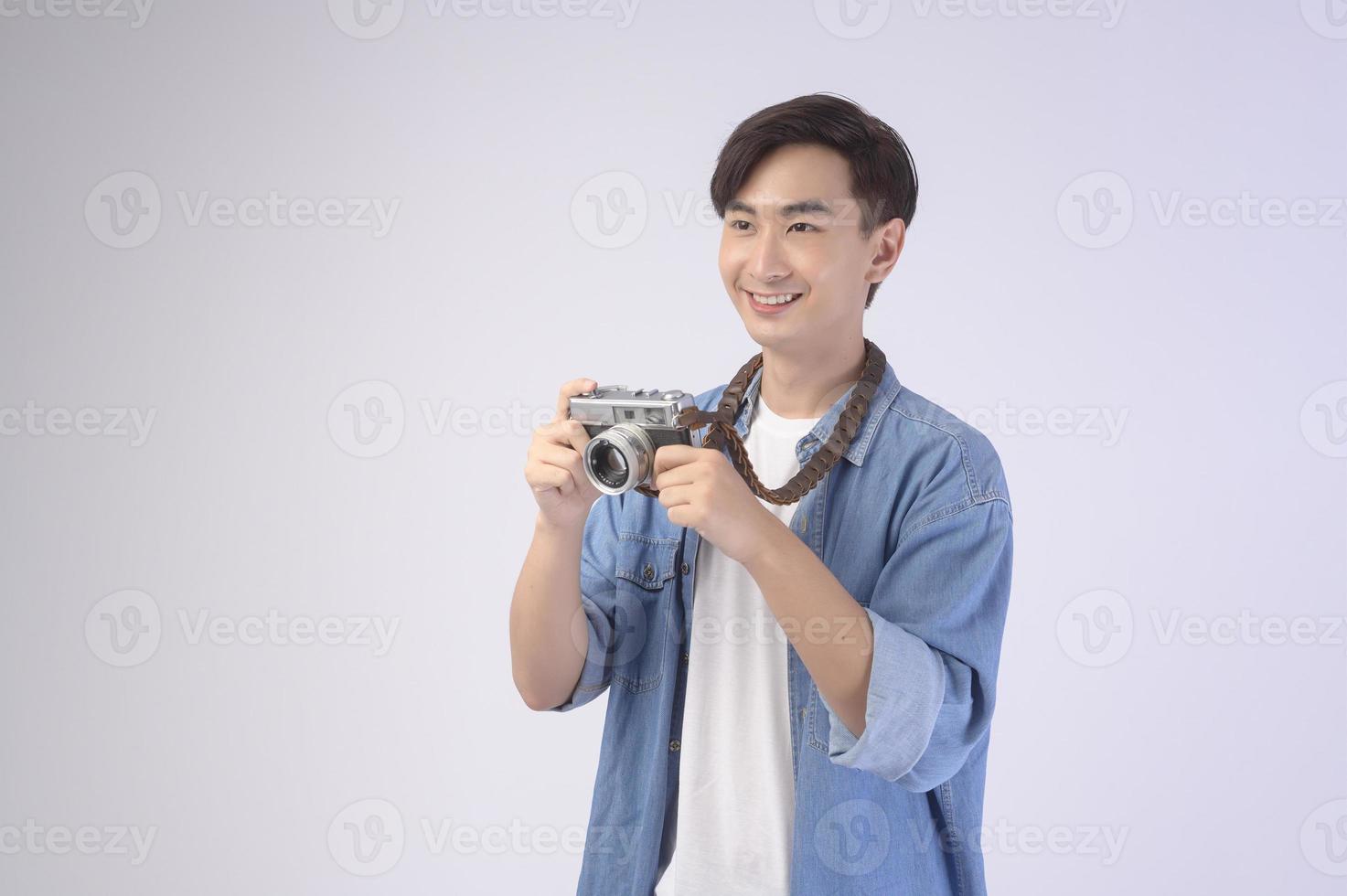 Young happy asian tourist man over white background studio, travel and holidays concept. photo