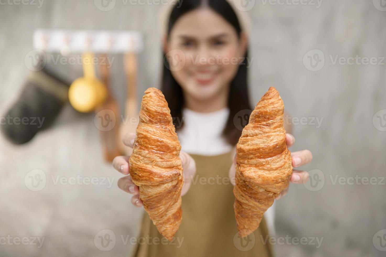 joven hermosa mujer está horneando en su negocio de cocina, panadería y cafetería foto