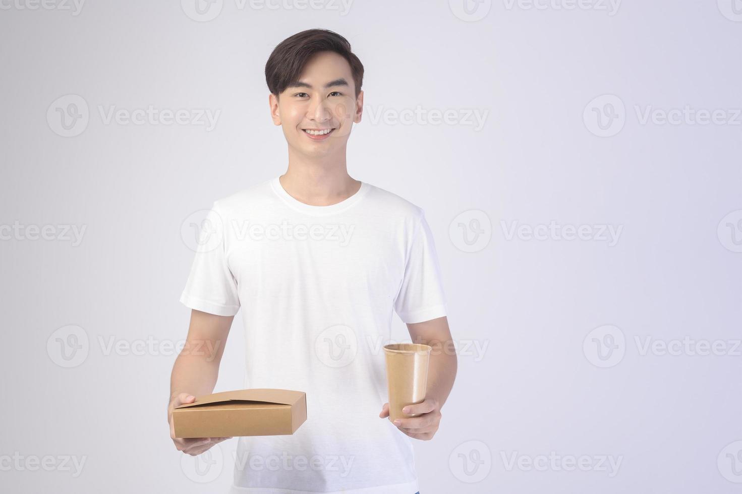 Young asian man holding paper cup and paper box over white background, Save earth concept photo