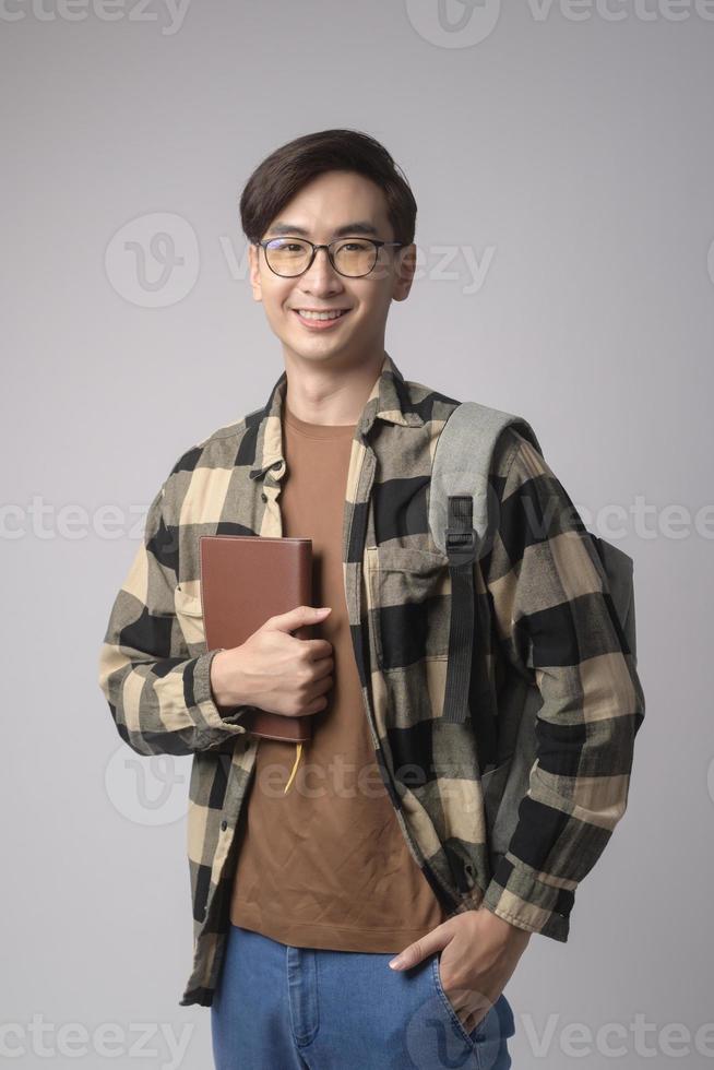 Portrait of an Asian university student over white background studio, education concept. photo