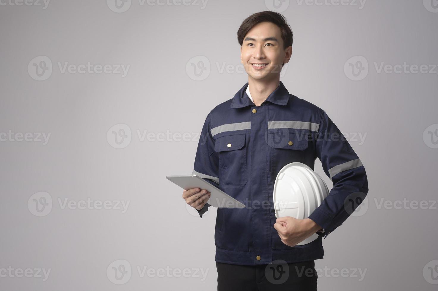 Portrait of male engineer wearing a protective helmet over white background studio. photo