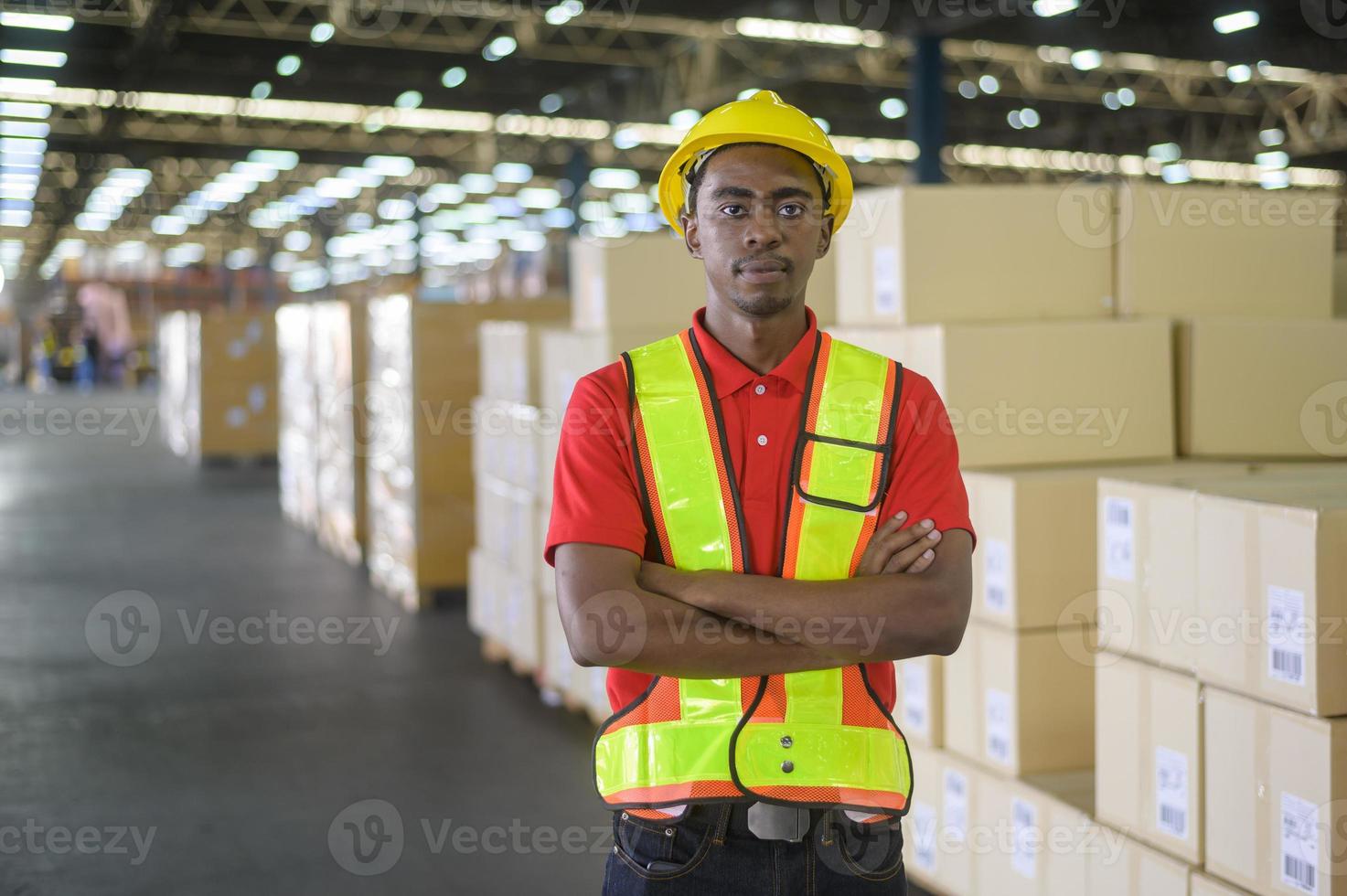 Portrait of young mixed race male worker wearing helmet in modern warehouse storage of retail shop photo
