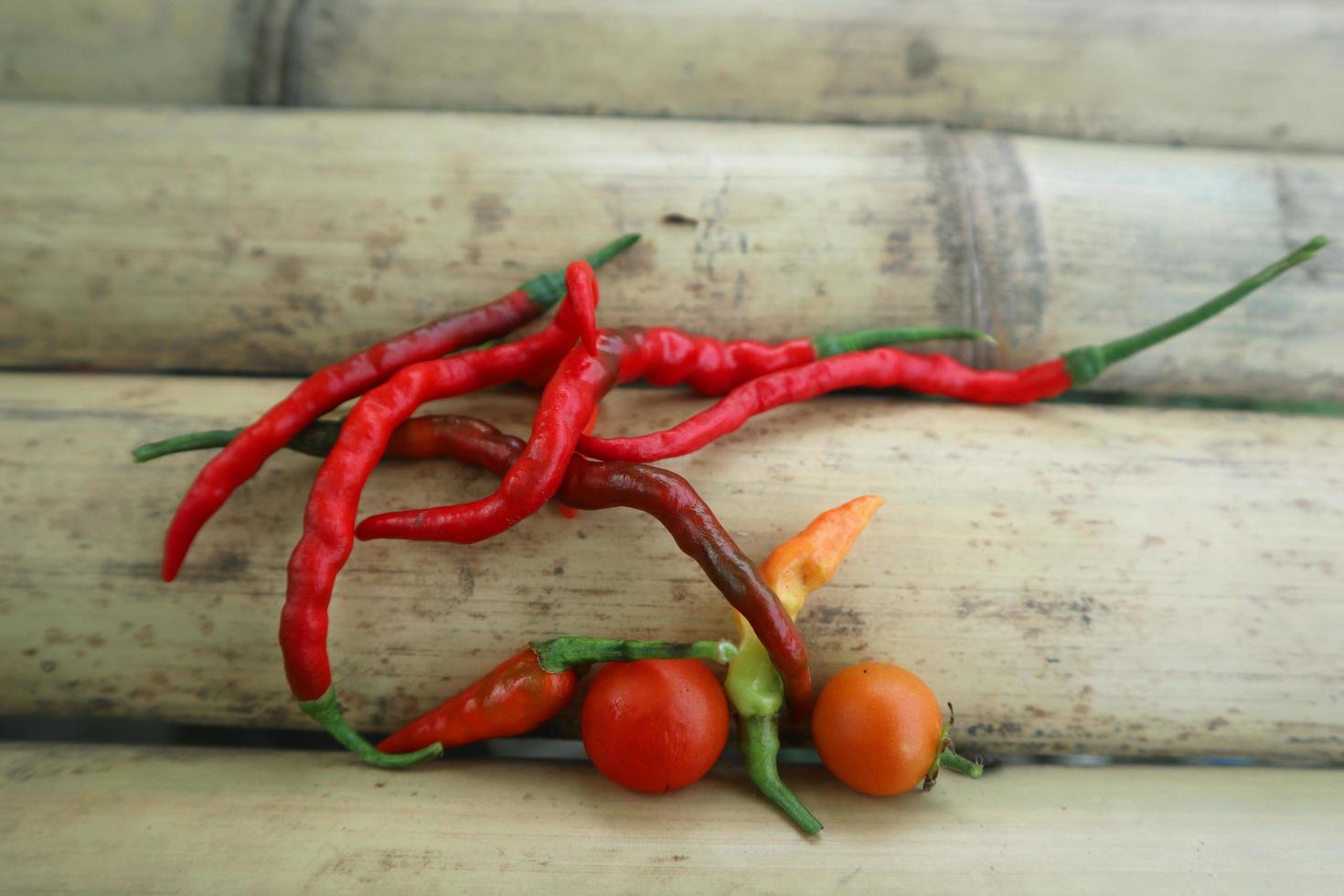 Hot chili peppers isolated on bamboo. Red and green Chile peppers plant photo