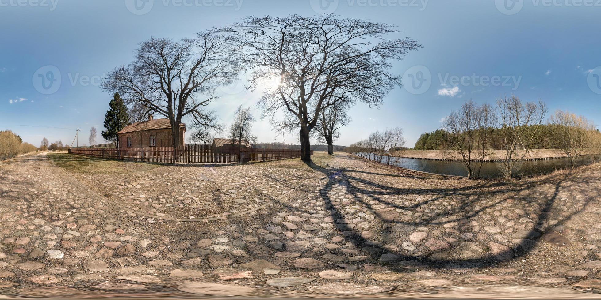 full seamless spherical hdri panorama 360 degrees angle view on gravel road near brick house in village near river in equirectangular projection, ready AR VR virtual reality content photo