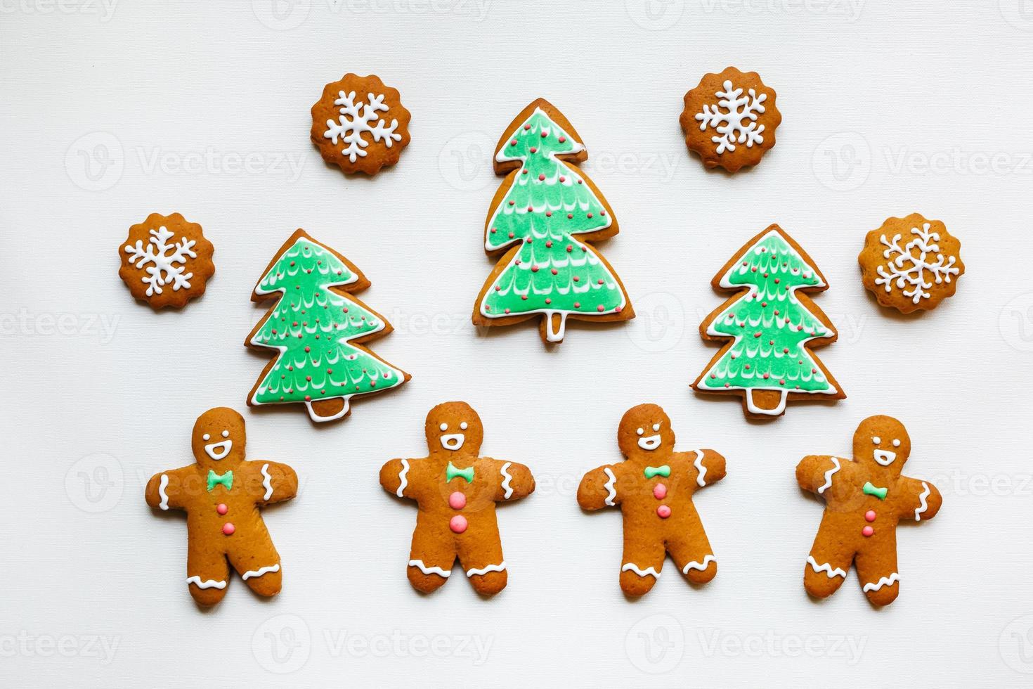 Handmade festive gingerbread cookies in the form of stars, snowflakes, people, socks, staff, mittens, Christmas trees, hearts for xmas and new year holiday on white paper background photo