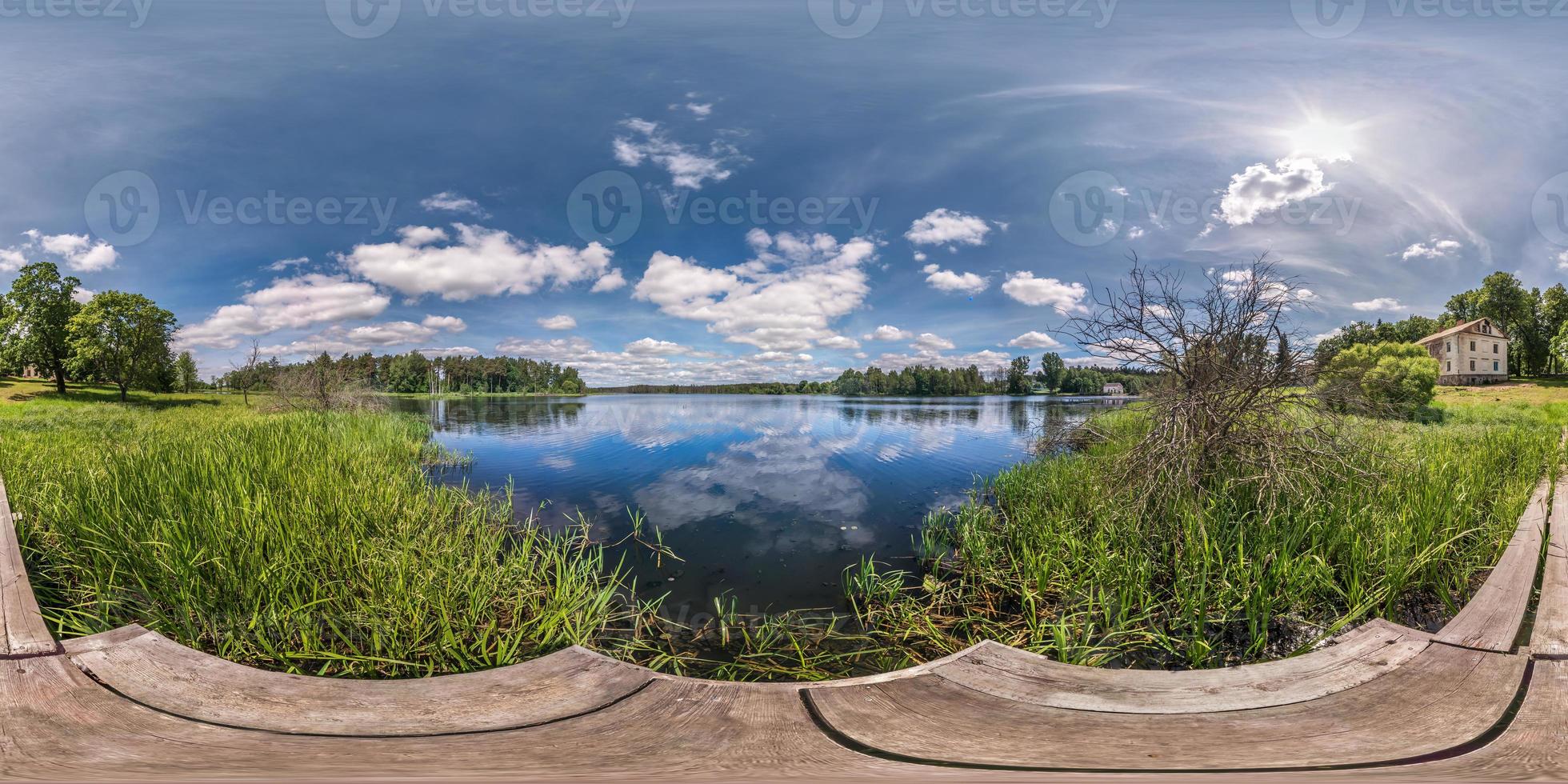 full seamless spherical hdri panorama 360 degrees  angle view on wooden pier of huge lake or river in sunny summer day and windy weather with beautiful clouds in equirectangular projection, VR content photo