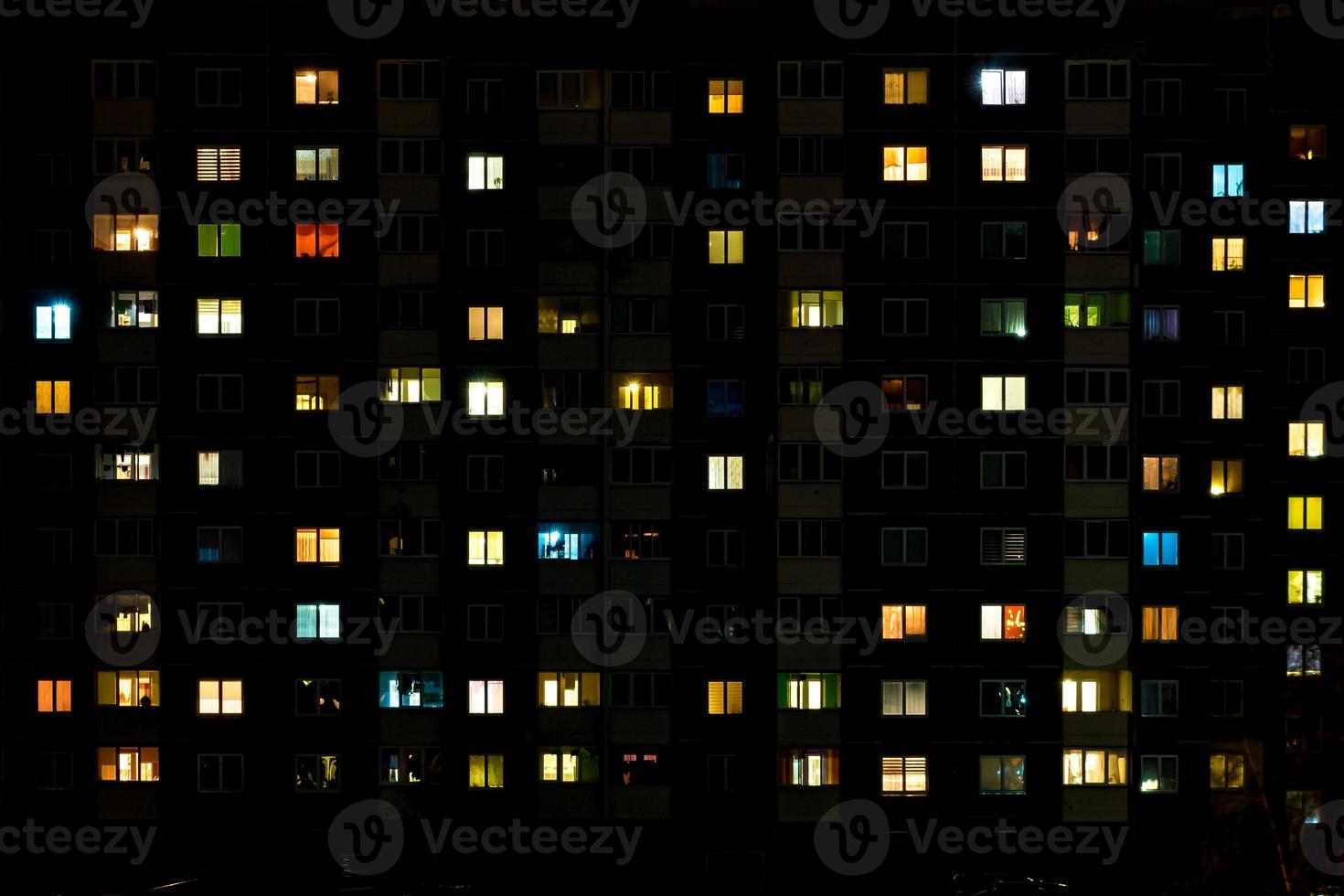 Night time lapse of Light in the windows of a multistory building. life in a big city photo
