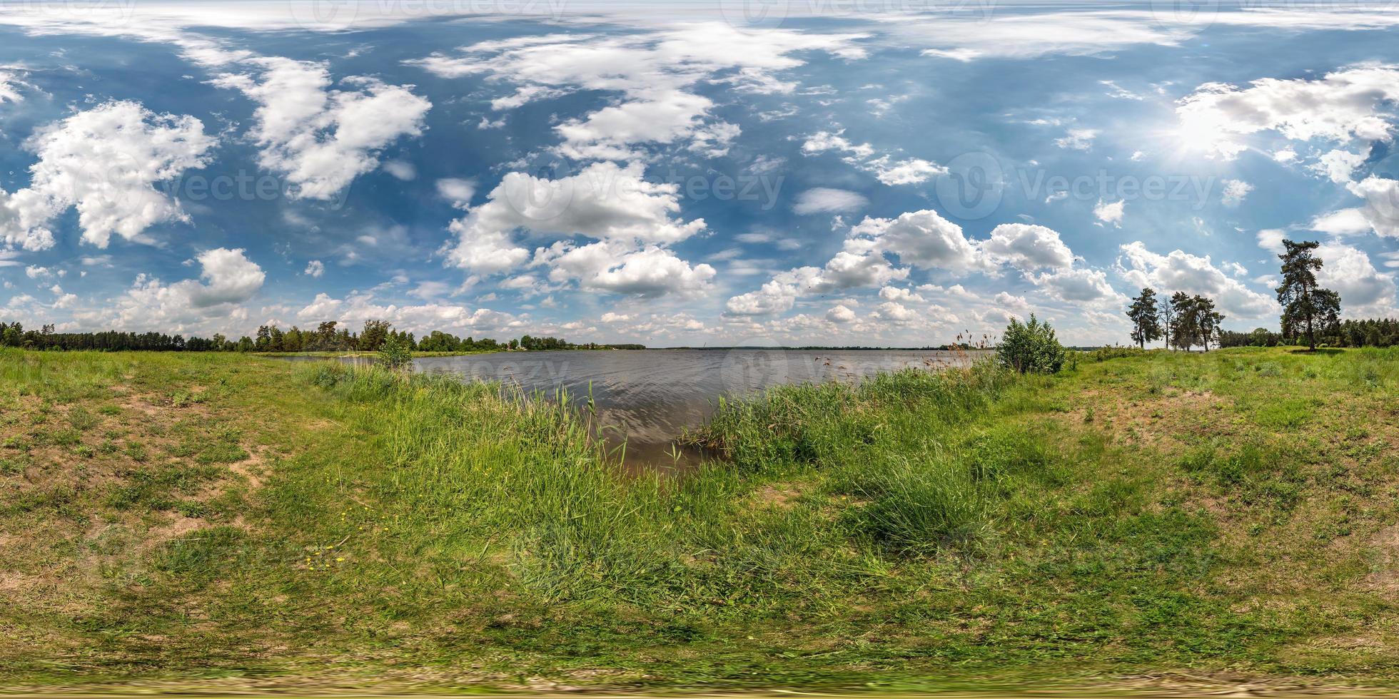 full seamless spherical hdri panorama 360 degrees angle view on grass coast of huge lake or river in sunny summer day and windy weather with beautiful clouds in equirectangular projection, VR content photo