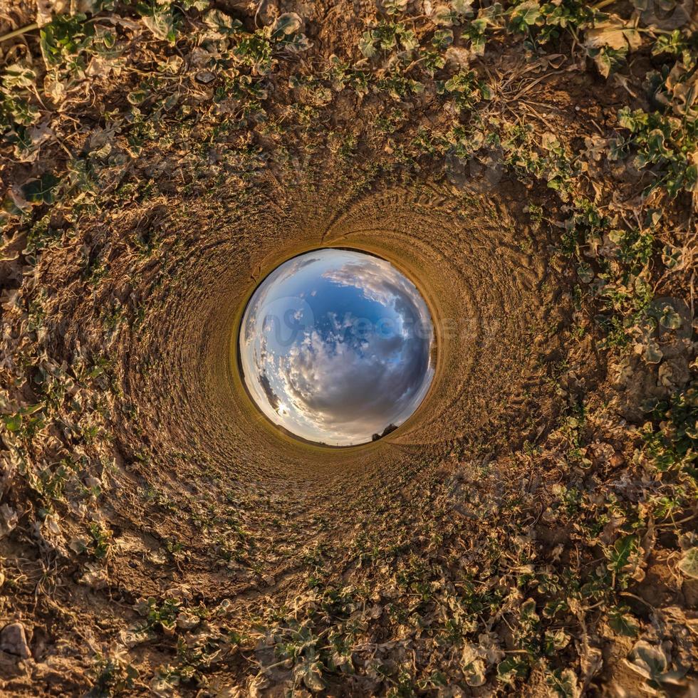 bola de cielo azul en medio del campo giratorio. inversión de la transformación del pequeño planeta del panorama esférico de 360 grados. curvatura del espacio. foto