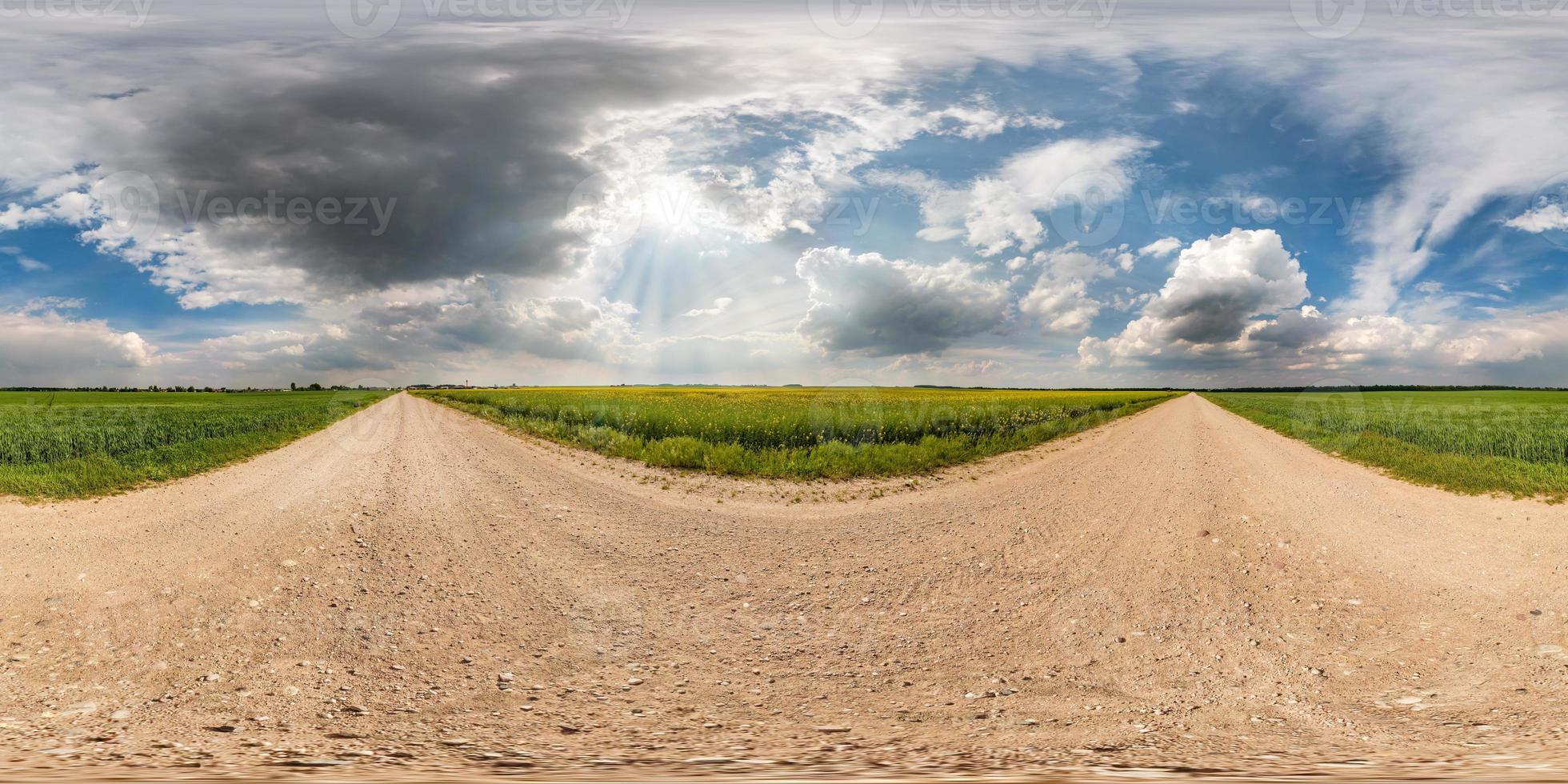 full seamless spherical hdri panorama 360 degrees angle view on gravel road among fields in summer day with awesome clouds before storm in equirectangular projection, for VR AR virtual reality content photo