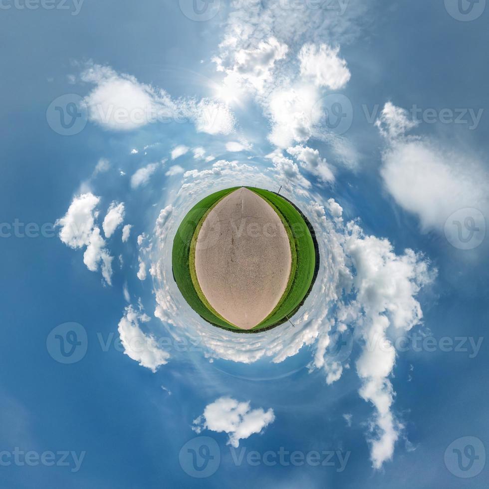 Little planet transformation of spherical panorama 360 degrees. Spherical abstract aerial view in field in nice day with awesome beautiful clouds. Curvature of space. photo