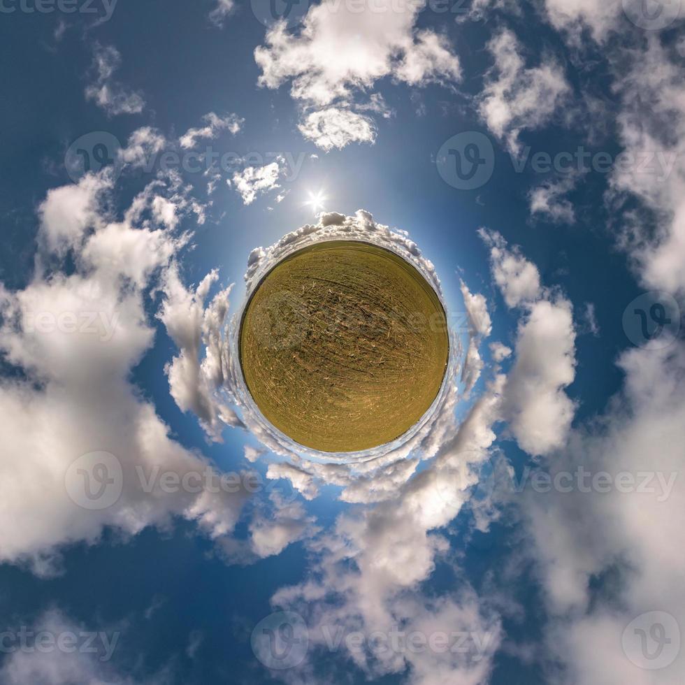 tiny planet in blue sky with sun and beautiful clouds. Transformation of spherical panorama 360 degrees. Spherical abstract aerial view. Curvature of space. photo